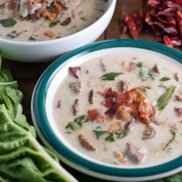 Spicy Italian sausage, fresh leaves, and potatoes in a creamy broth topped with crumbled bacon. An easy and yummy Olive Garden Zuppa Toscana Soup recipe.