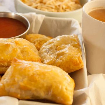 This is an image of indian chicken puffs with tea on the side, ketchup as dipping and some tapioca chips